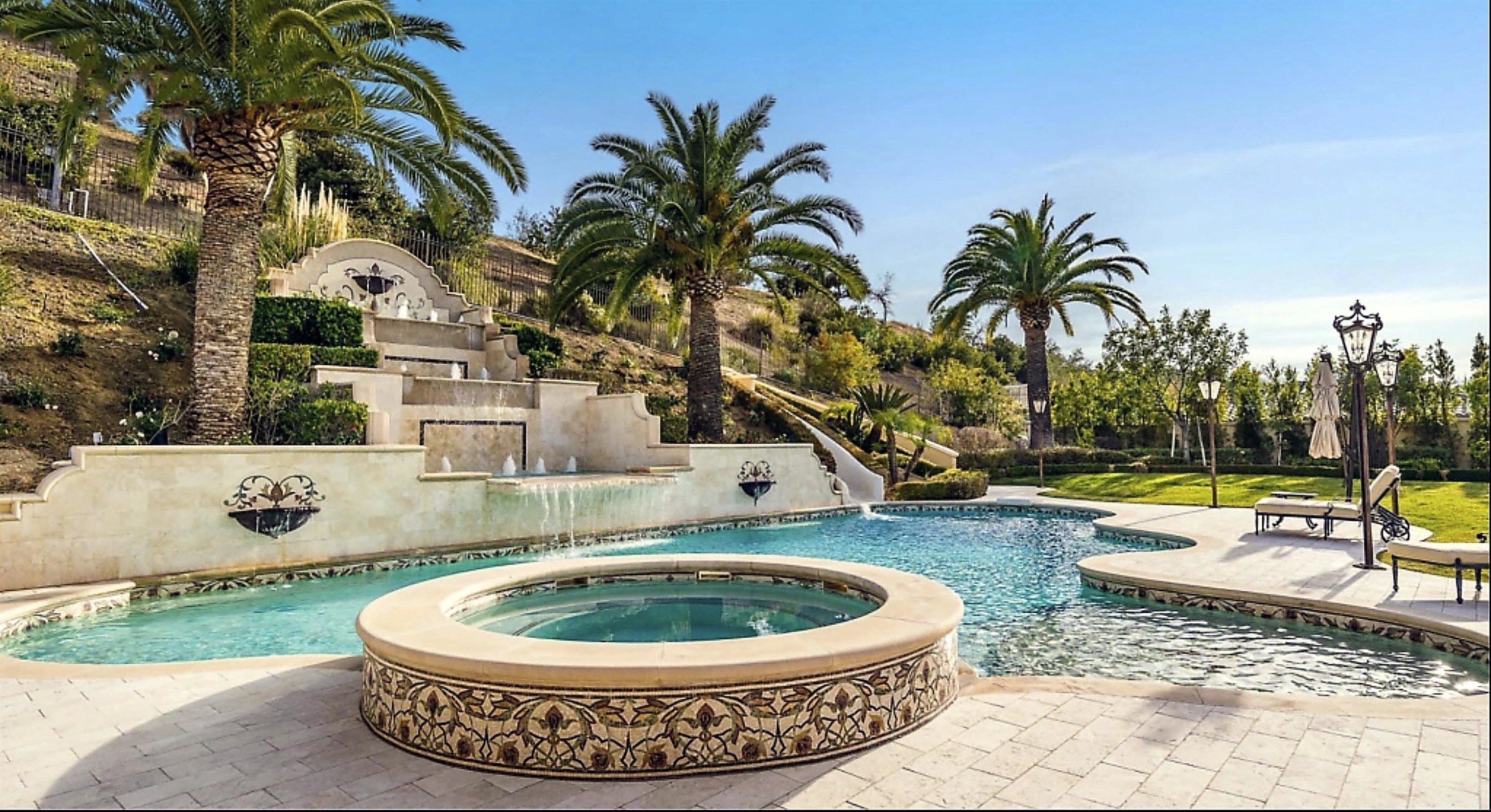 A different angle of the pool, which shows it also has a fountain above it that creates a waterfall that runs into the pool