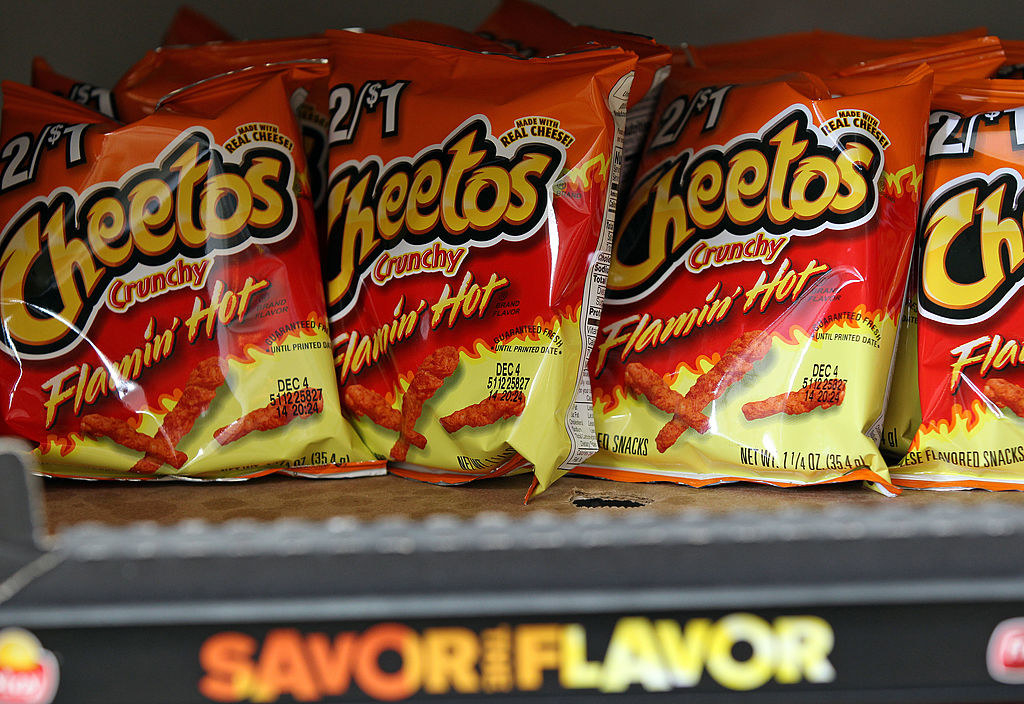 Bags of flamin&#x27; hot cheetos on a shelf.
