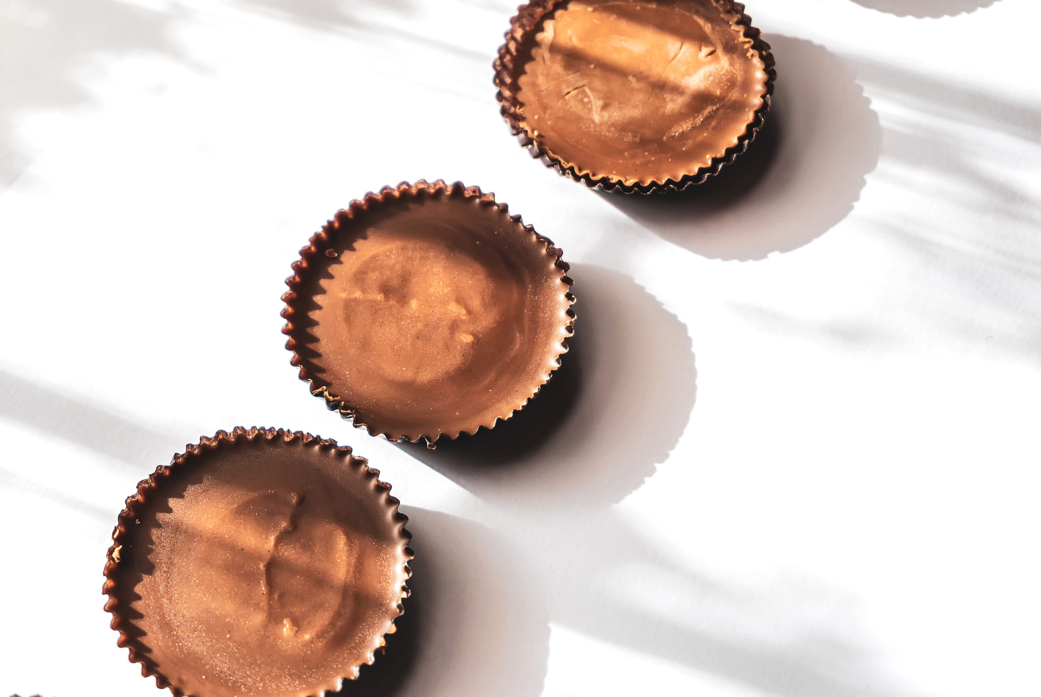 Three chocolate peanut butter cups in their wrapping.