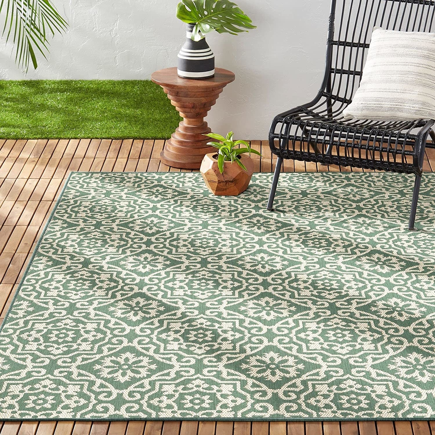 the green and white outdoor rug on a patio