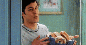 A man holding a basket of bagels.