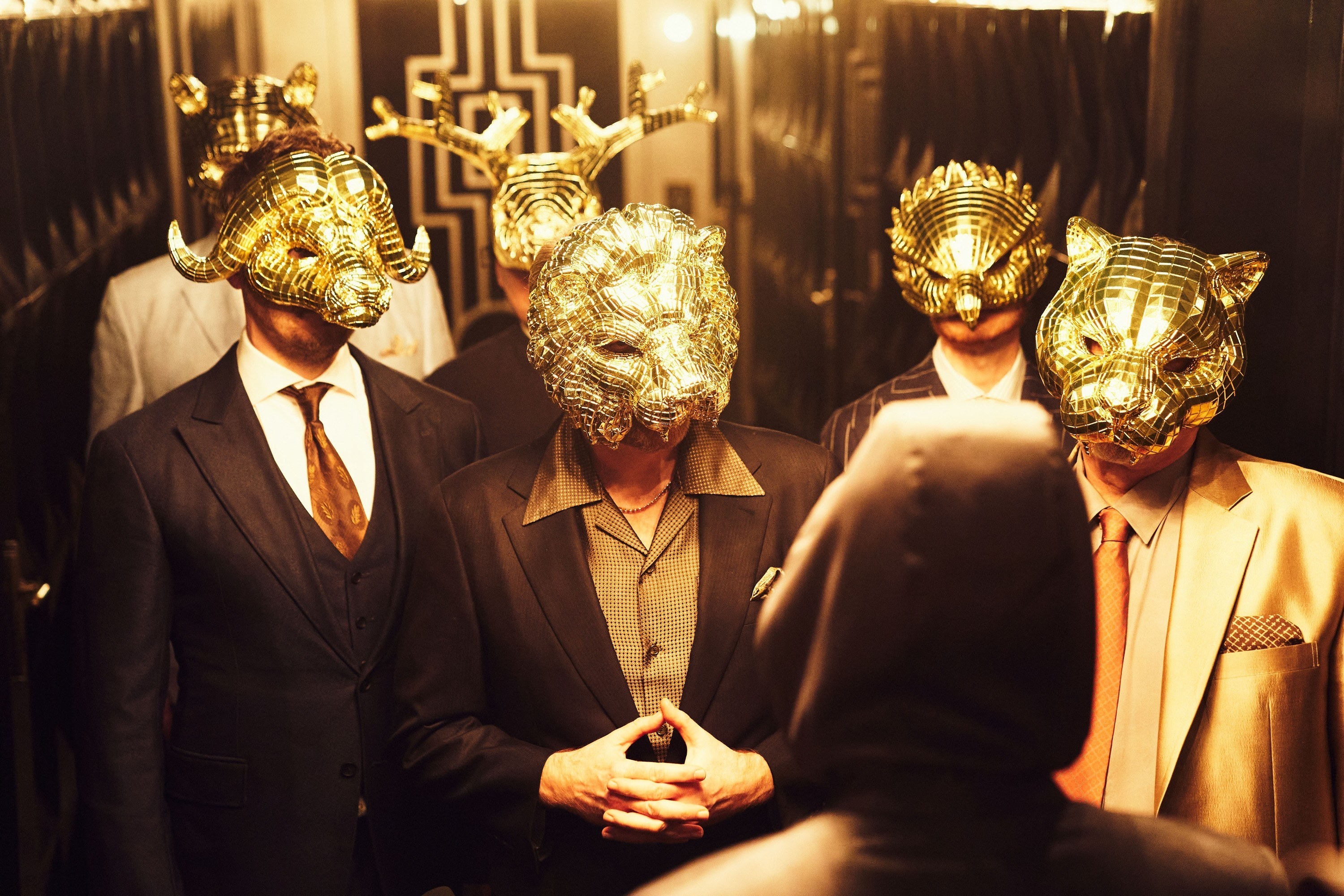 men in suits wearing animal masks