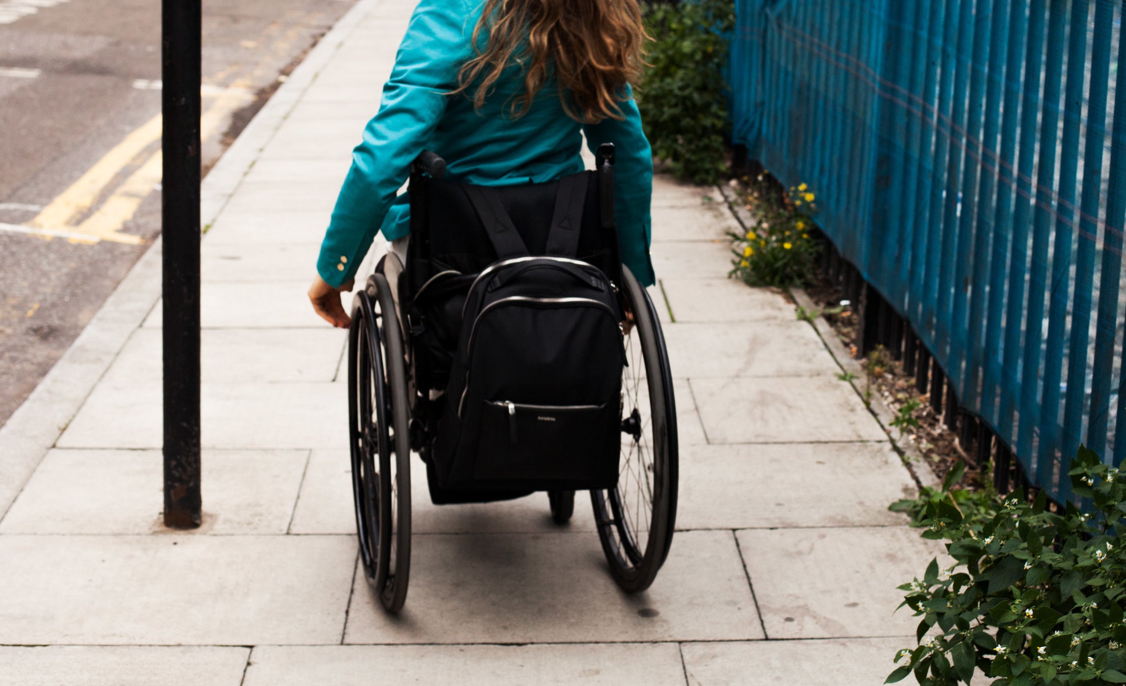 woman in wheelchair on sidewalk