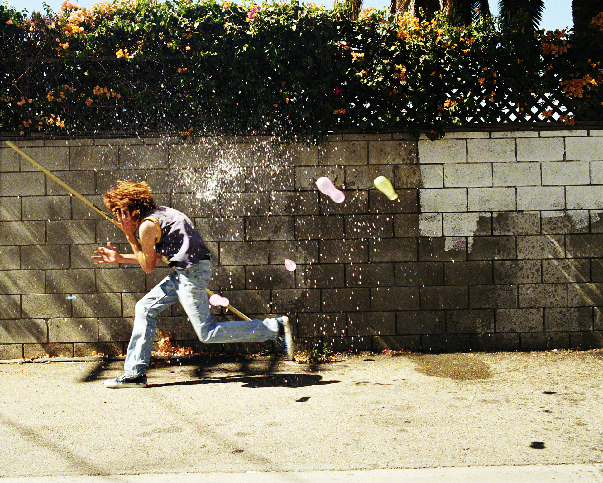 a person runs as they get hit with water balloons