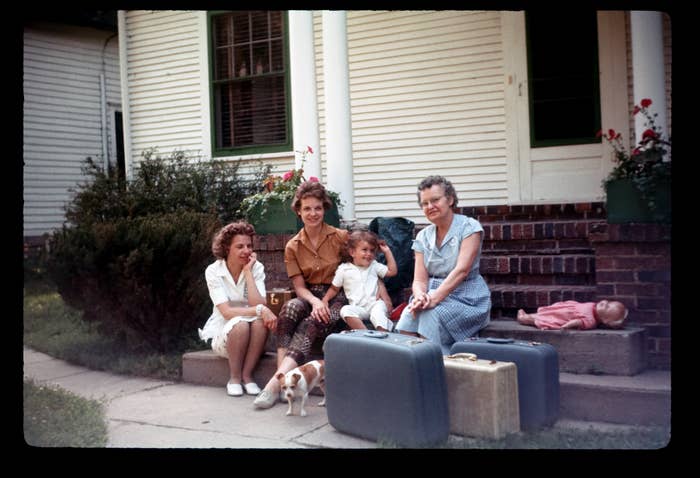 A family sits on the steps of a house