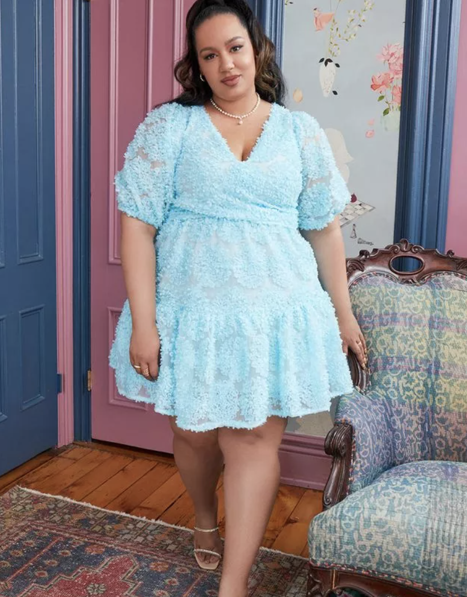 model wearing a light blue mini dress with flower applique