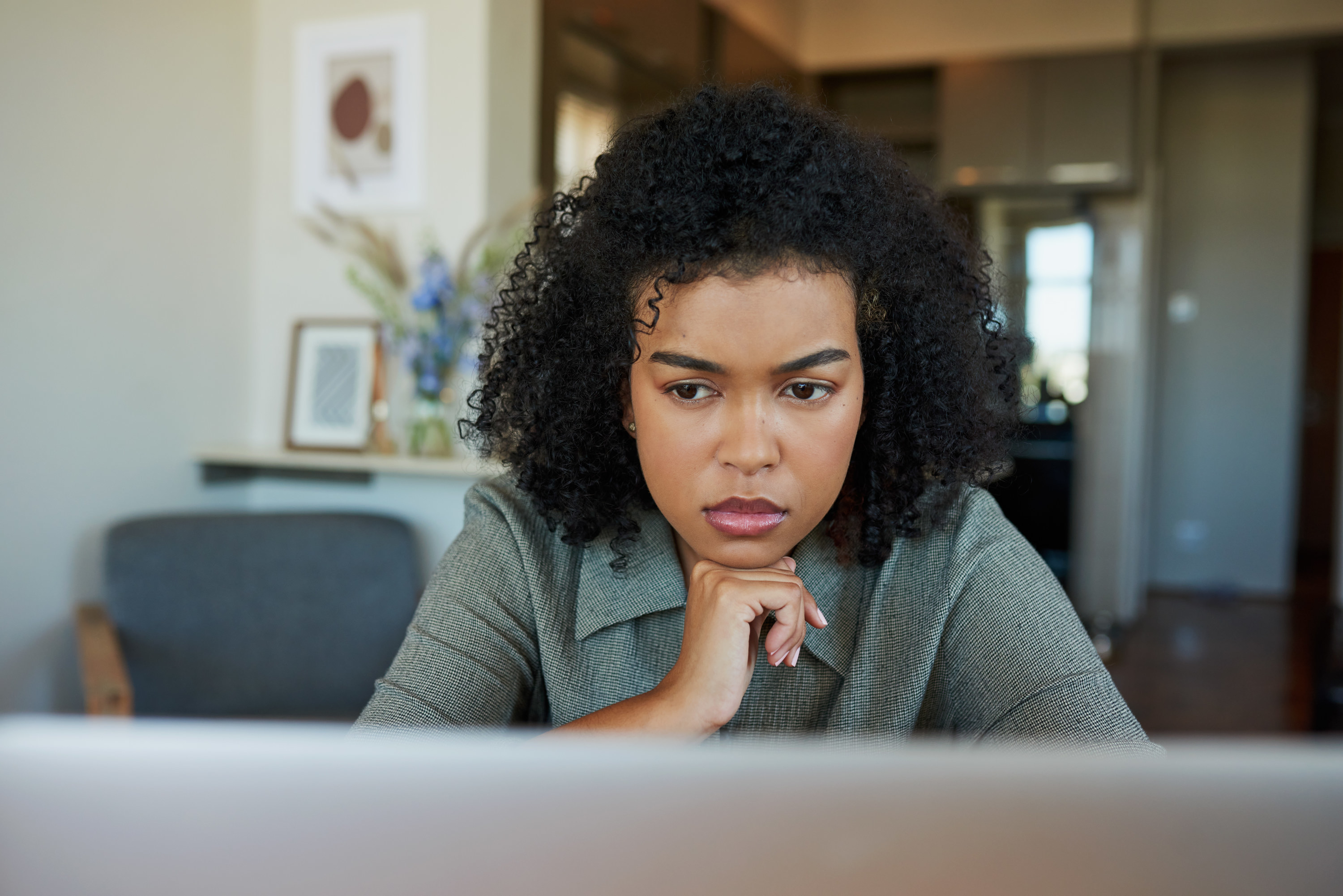 A woman looking at her computer with concern