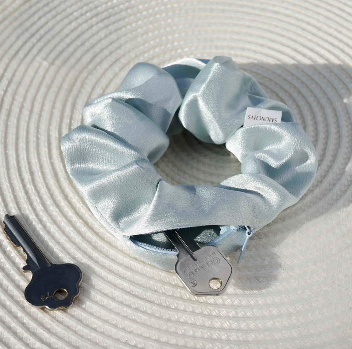 the blue satin scrunchy with the zipper open and a key poking out