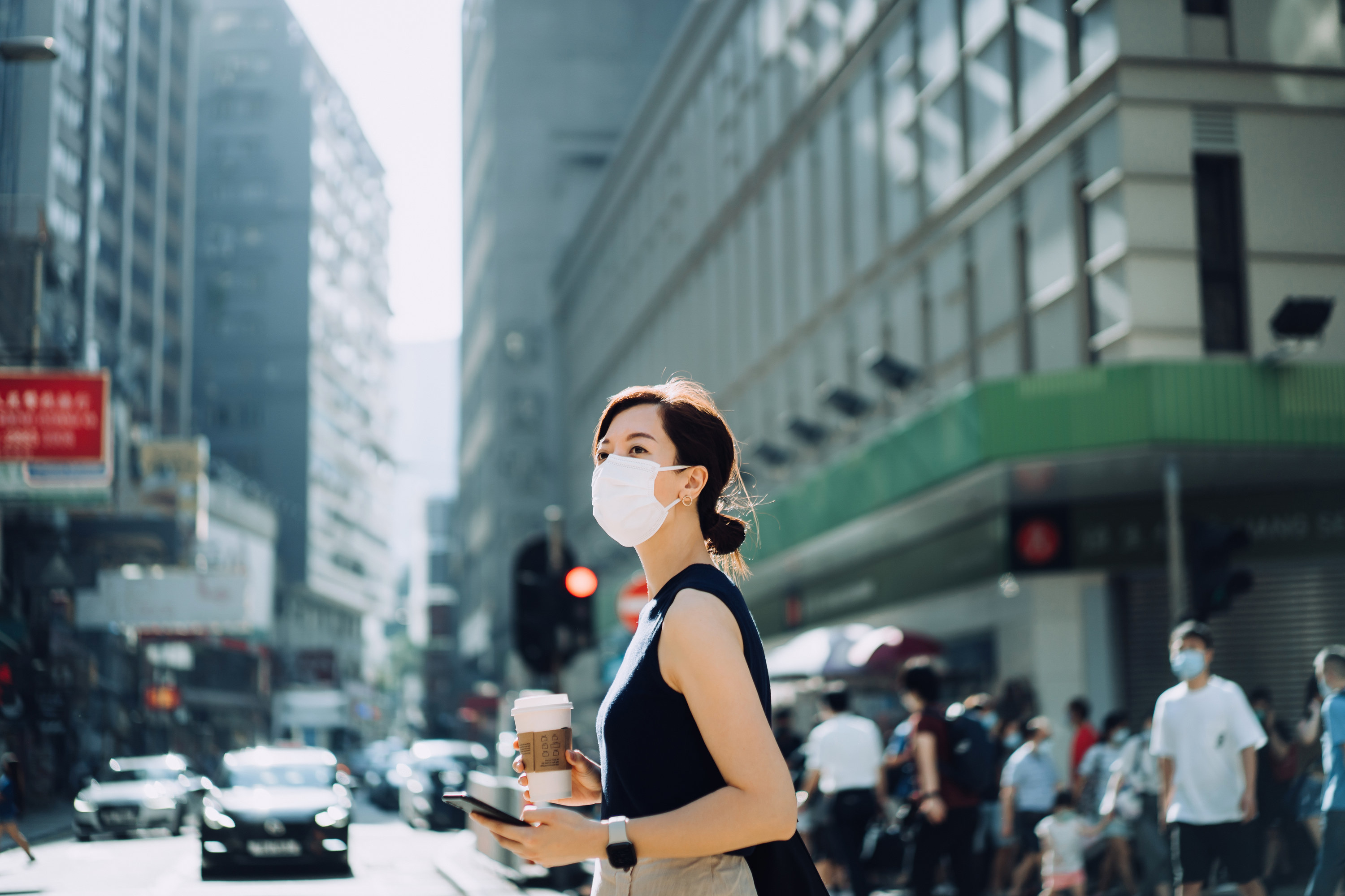 A woman with a mask on while she&#x27;s outdoors