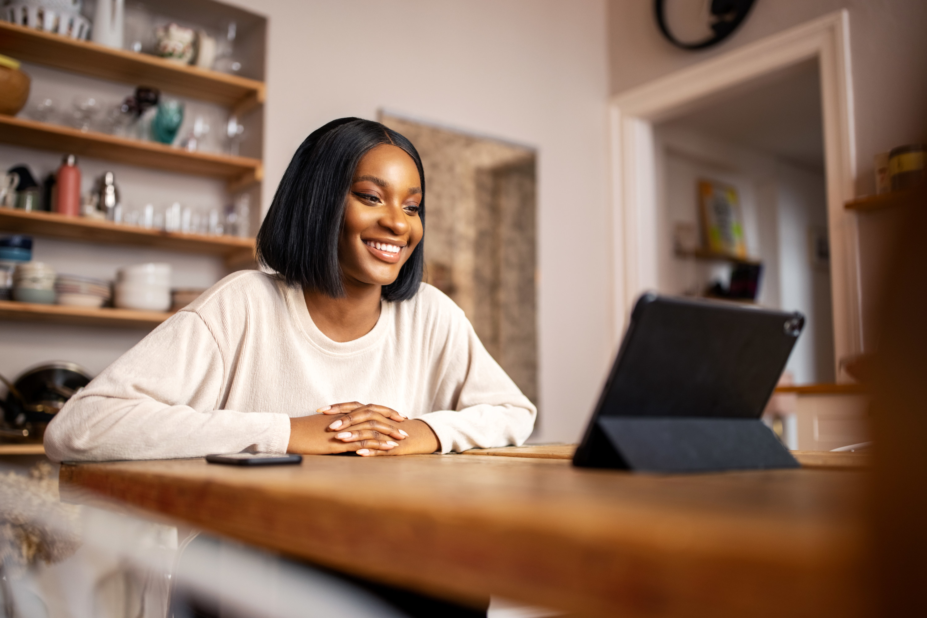 A woman talking to someone on a video call inside their home