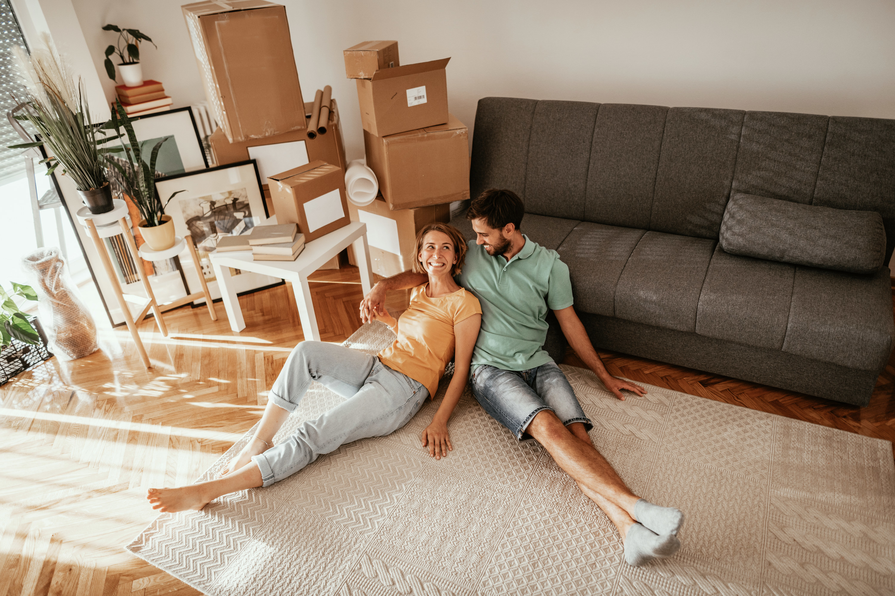 Couple sits on the floor of their new home
