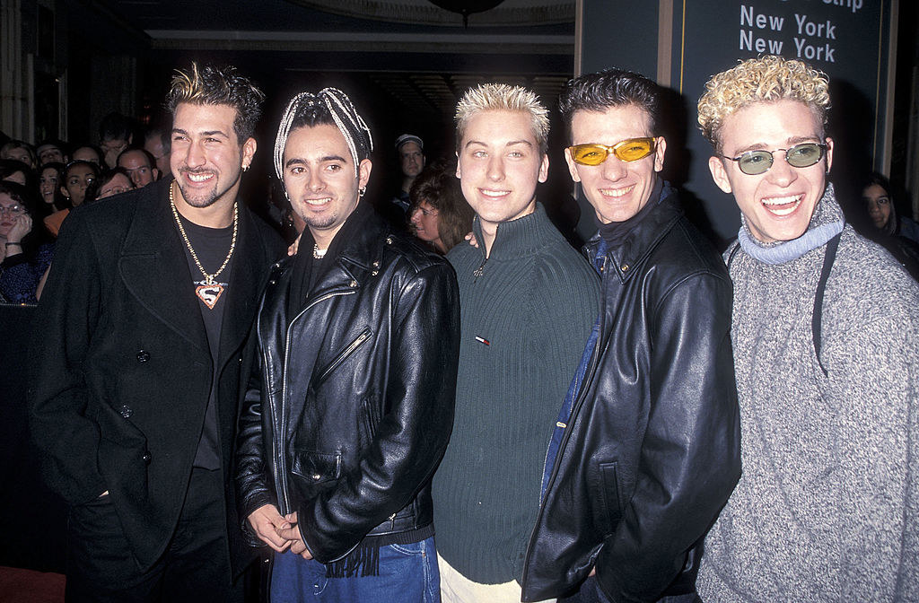 The members of NSYNC, including Chris Kirkpatrick, with short, spiky/curly hair