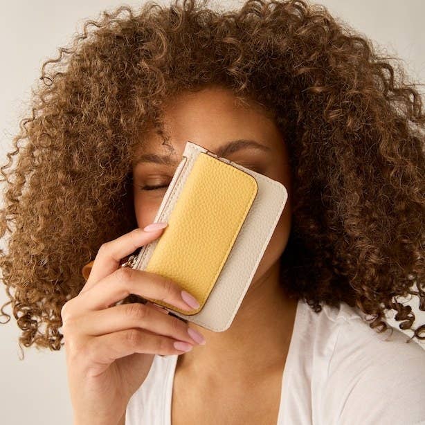 A person holding the card holder in front of their face