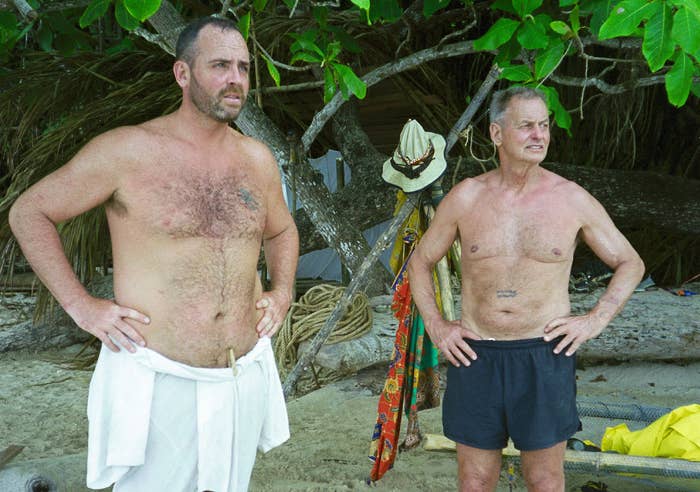 Richard Hatch and Rudy Boesch stand at camp