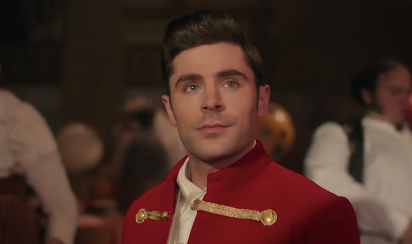 Zac Efron in a red jacket looking up/off-camera.