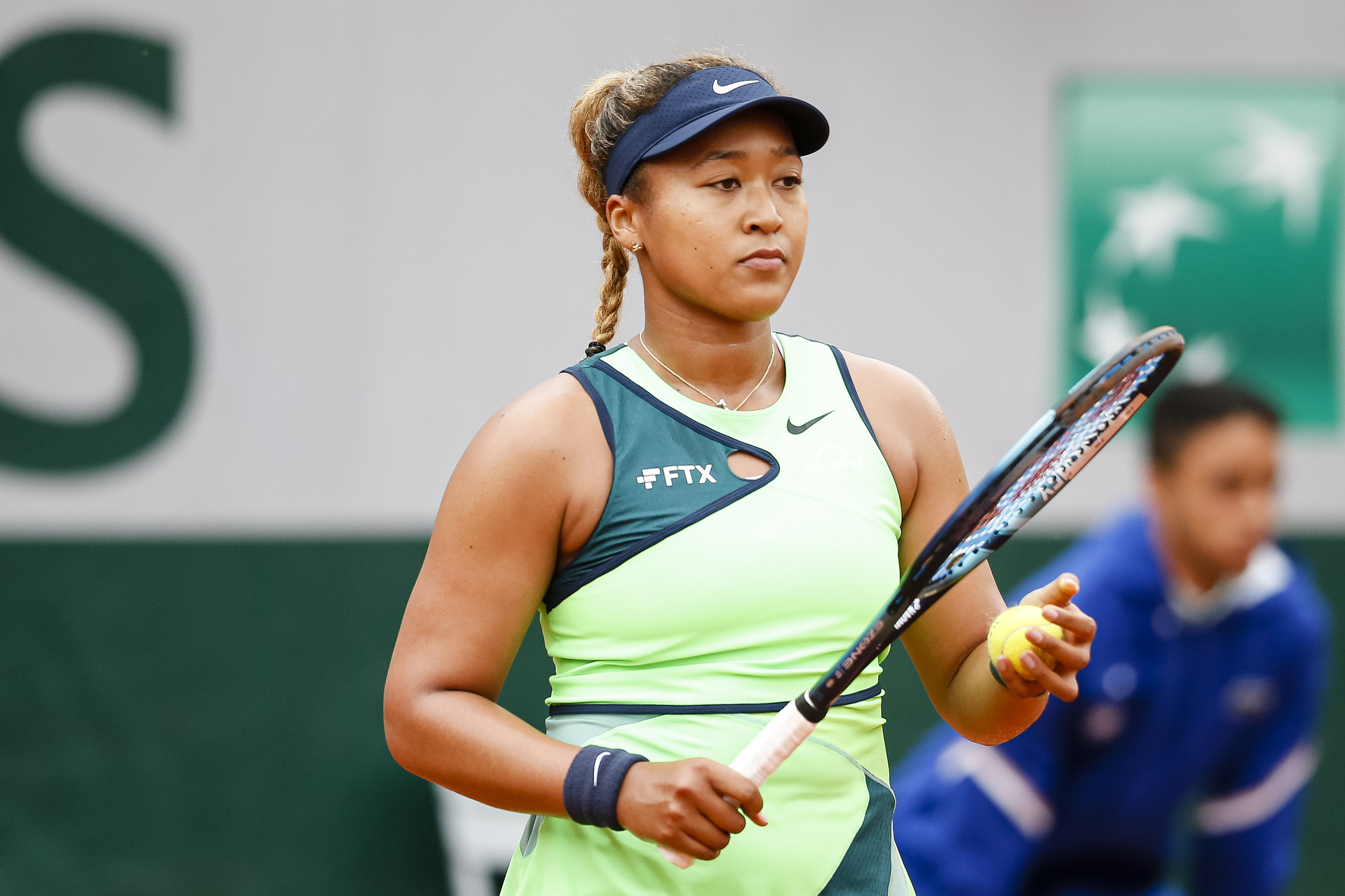 Naomi Osaka with a tennis racquet in hand.