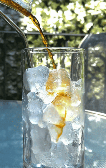 GIF of author pouring iced coffee into a glass with ice
