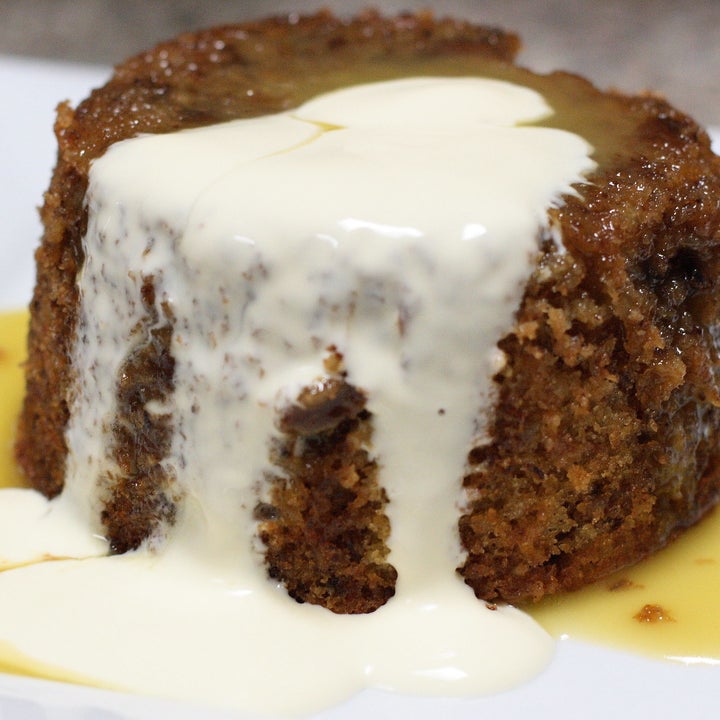 A sticky date pudding with melting ice cream on top