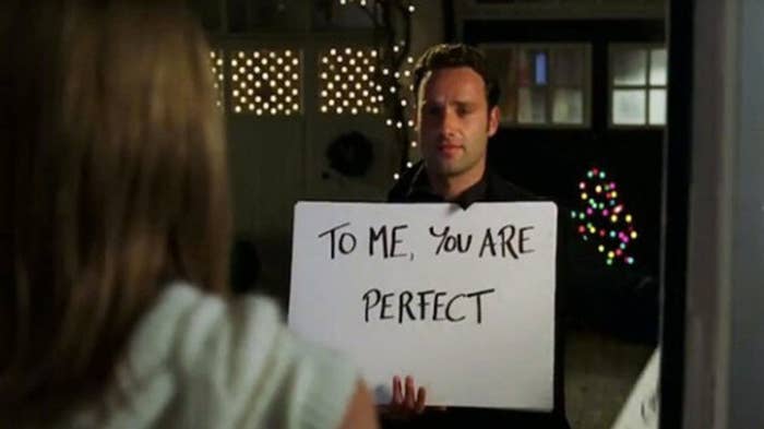 Andrew Lincoln as Mark in love actually holding a card that says to me you are perfect