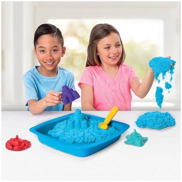 Two kids playing with blue sand
