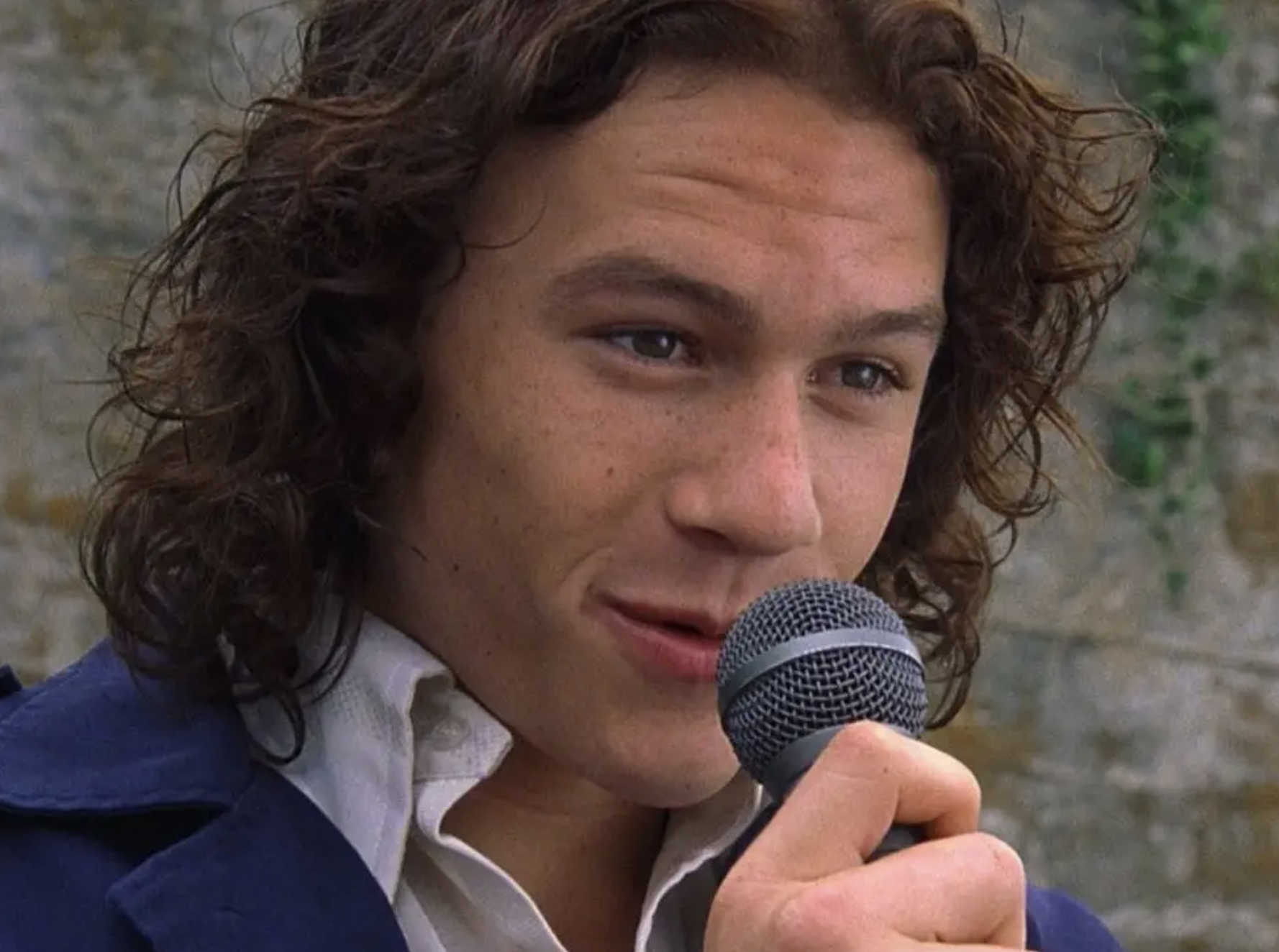 heath ledger singing into a microphone in a scene from 10 things i hate about you