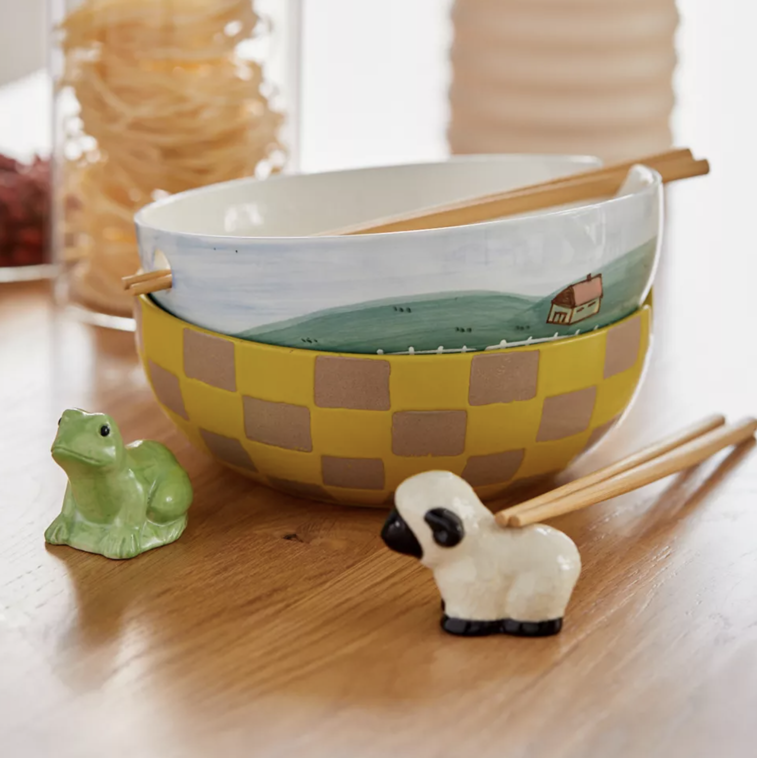 Two stacked bowls on a table with the chopstick holders in front of them