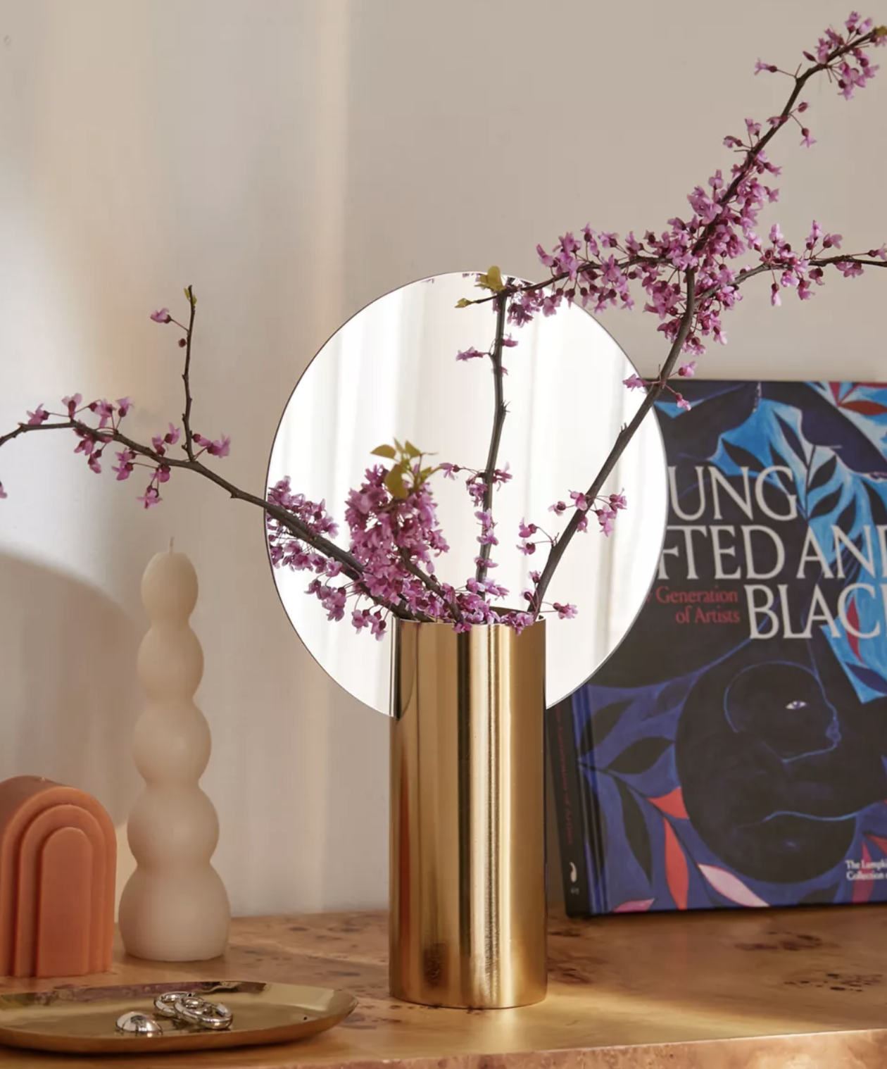 A bouquet of flowers in the vase on a table covered in trinked