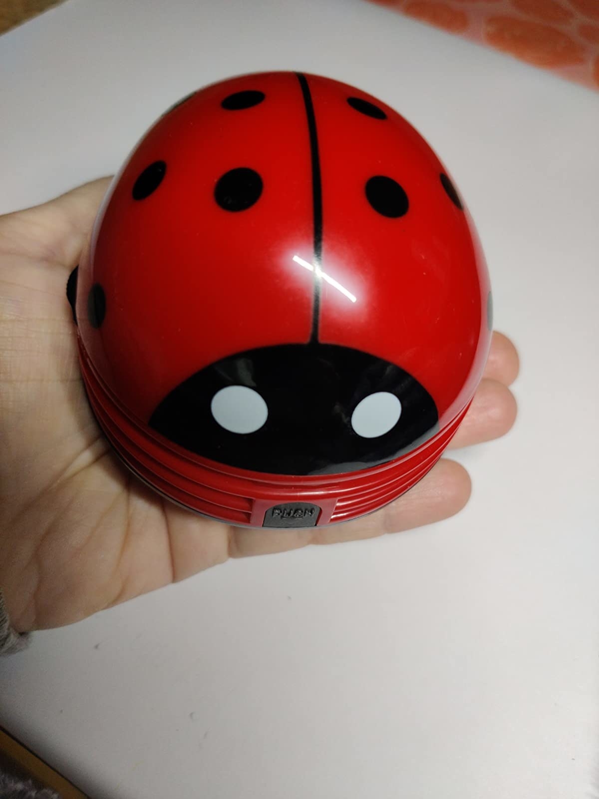 reviewer photo of them holding the red lady bug vacuum cleaner