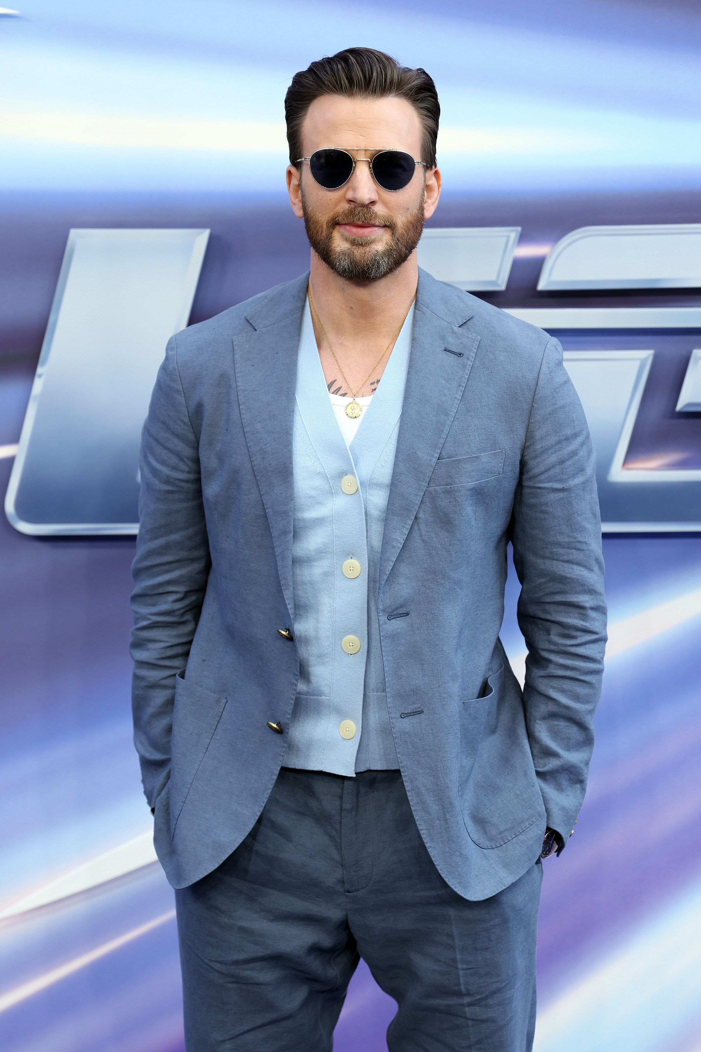 Chris Evans wearing sunglasses with his hands in his pockets