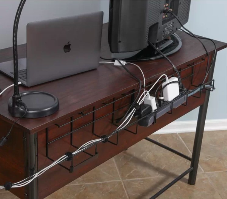 Wire organizer holding cables on the back of a desk