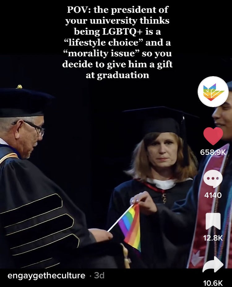 A fifth student with a pride flag at graduation