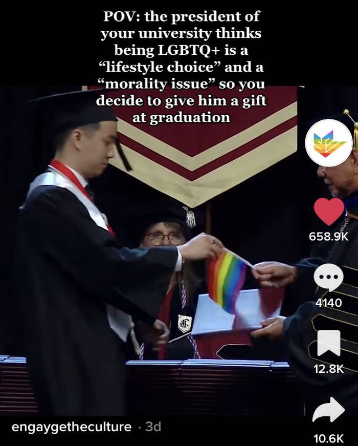 A different student hands the president a Pride flag at graduation