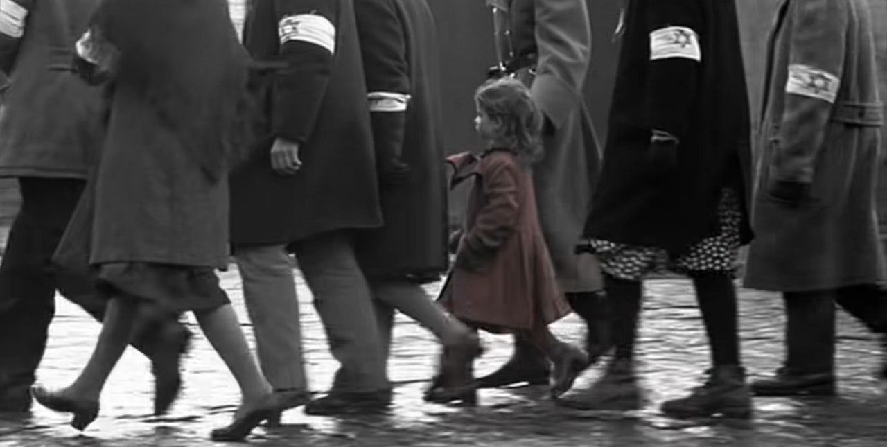 The girl in the red dress walking with a crowd of Jews in &quot;Schindler&#x27;s List&quot;