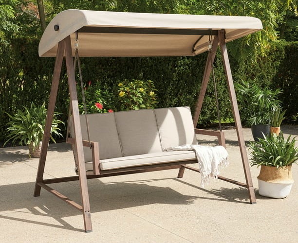 the beige bench swing hanging from a wooden a-frame