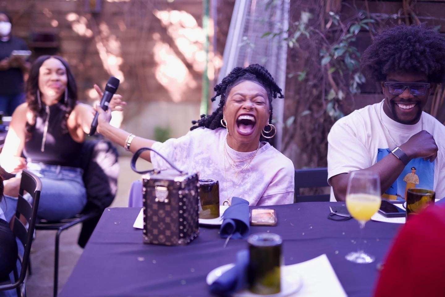 Chanise laughs while holding a mic