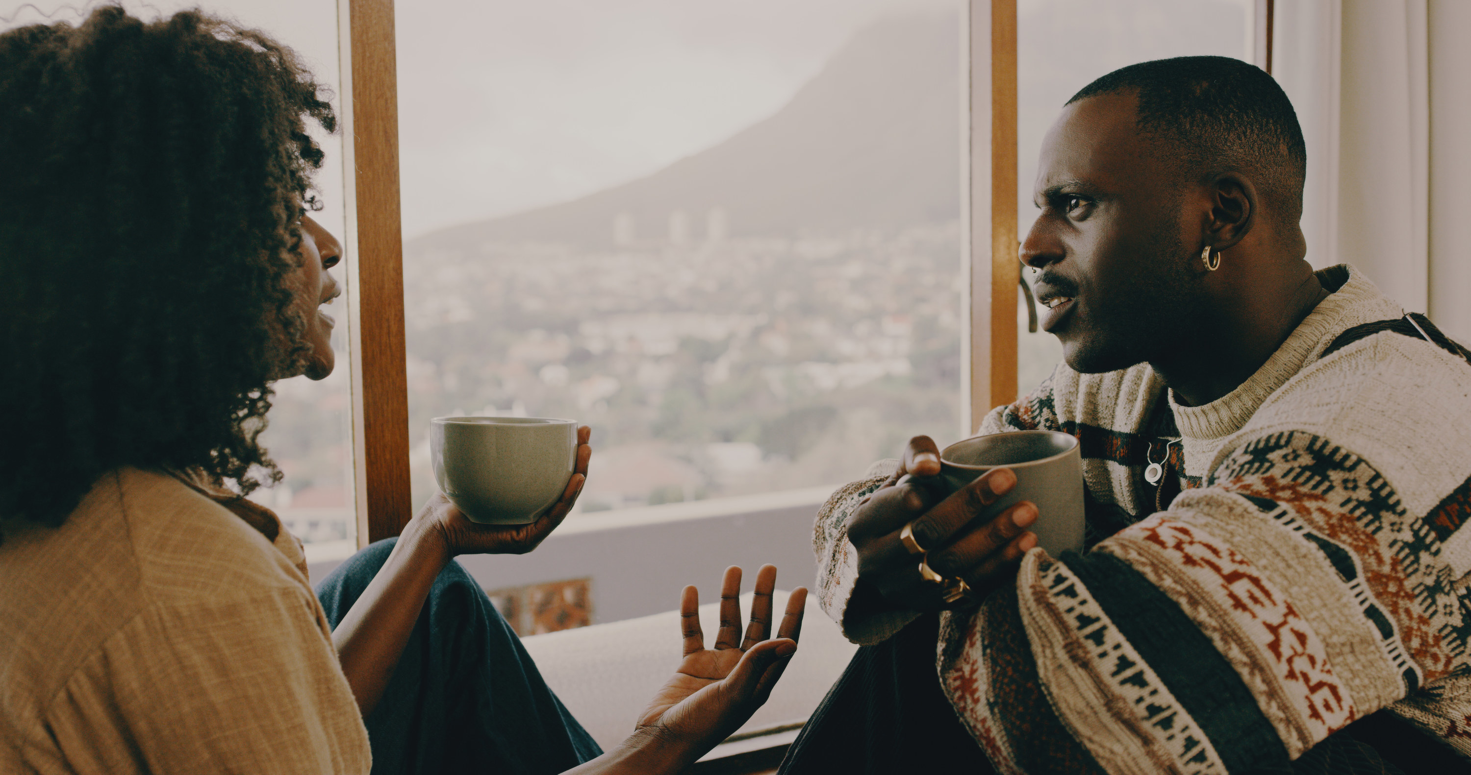 A man and woman talking while drinking coffee