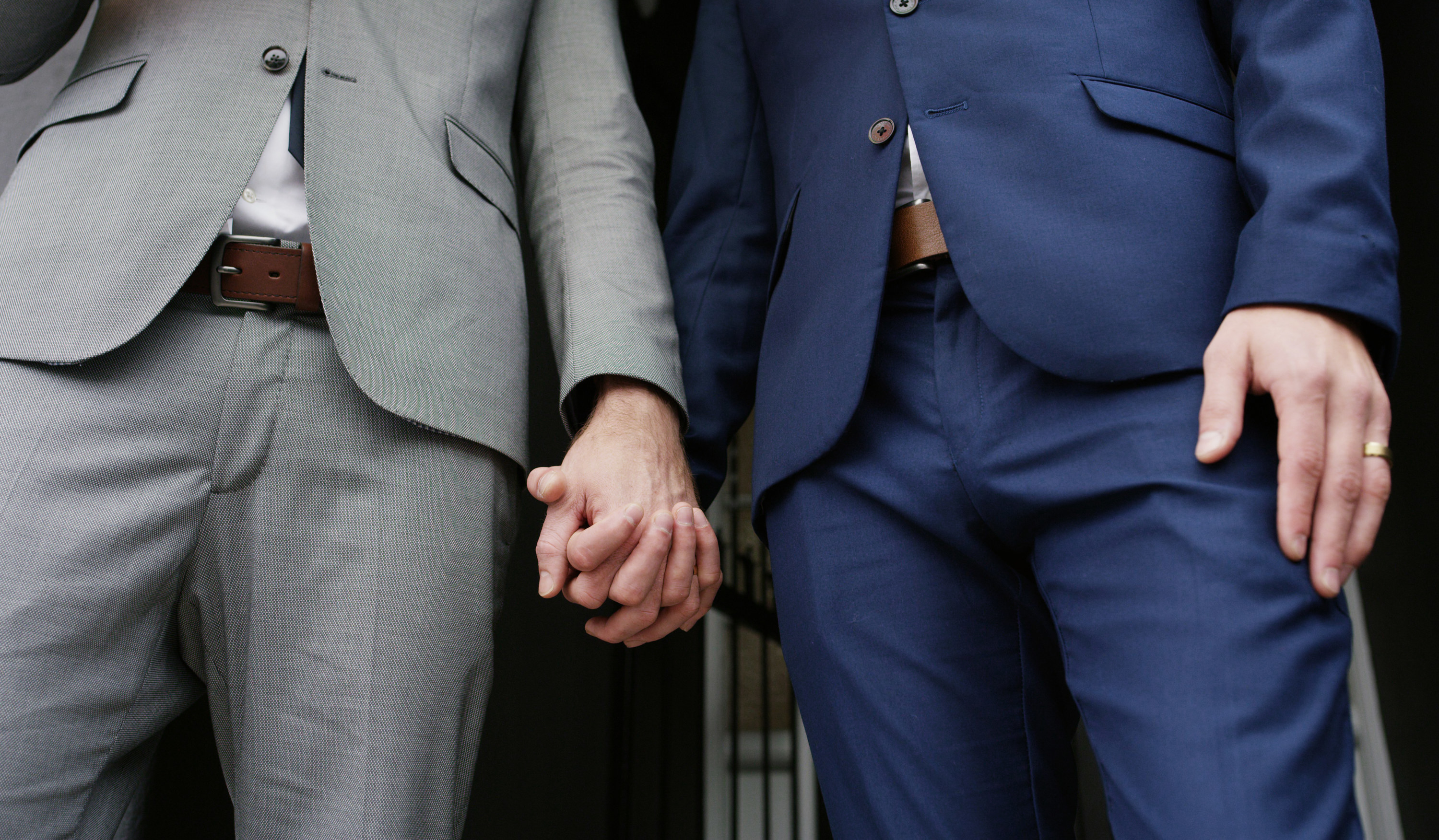 gay couple holding hands on their wedding day