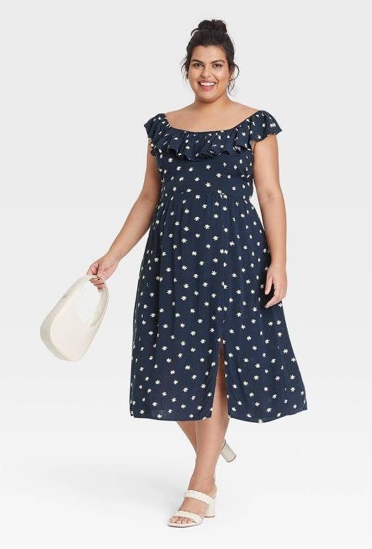 model wearing the navy and daisy printed dress