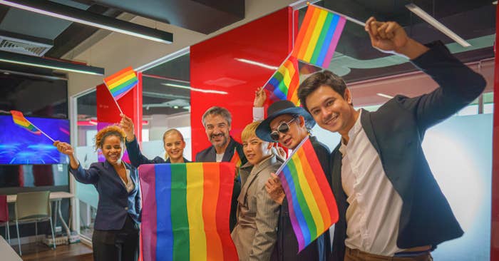 business people waving pride flags in an office
