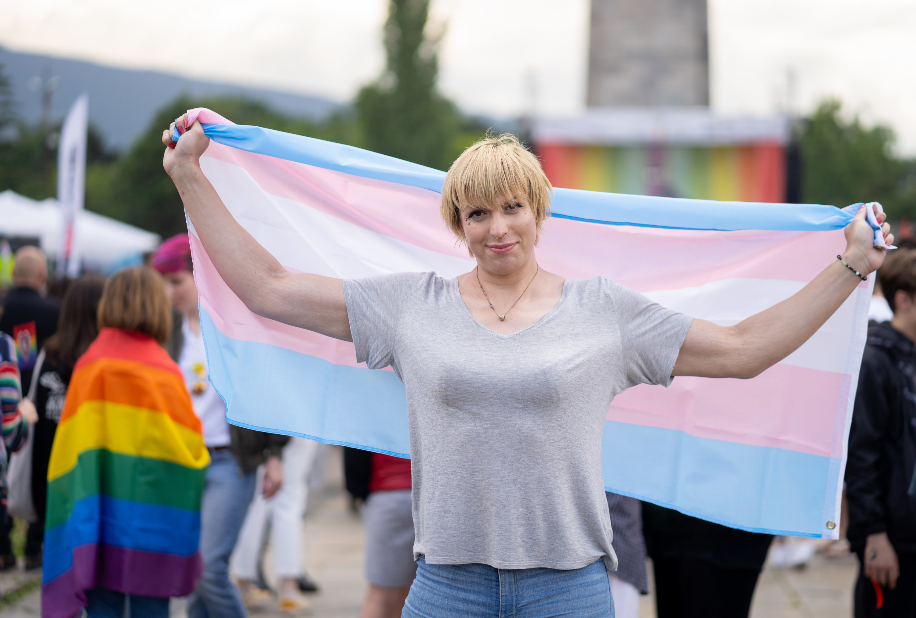 woman holding a trans flag at a Pride event