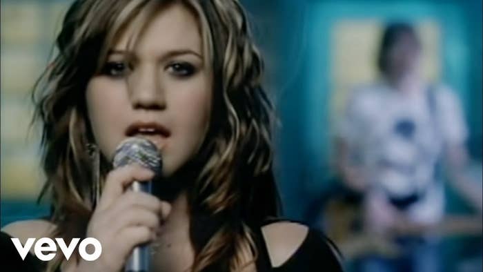 Kelly Clarkson sings into the microphone while looking at the camera