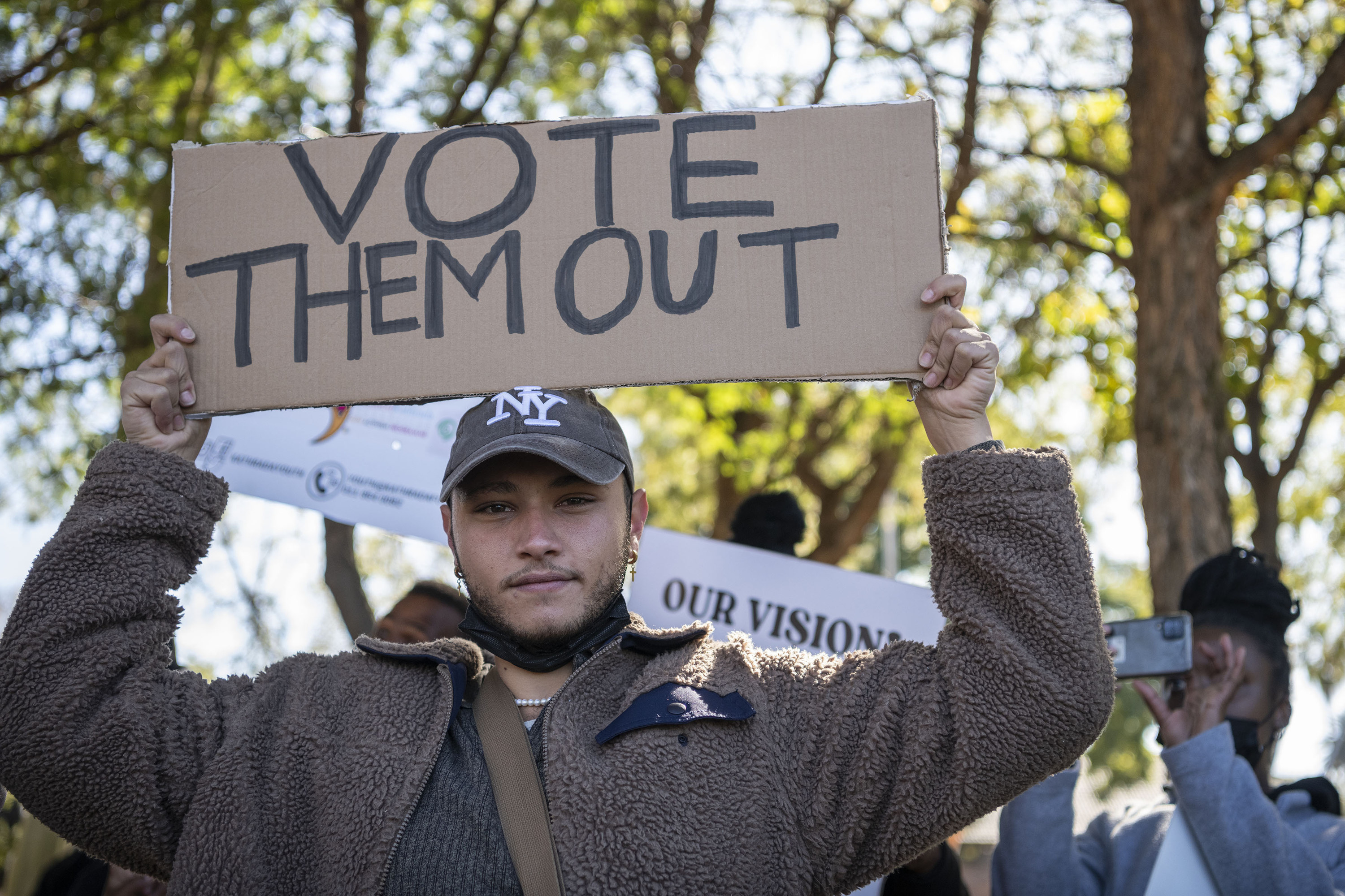 a man holds a sign saying &quot;vote them out&quot;