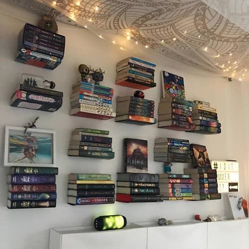 several piles of books mounted on the wall