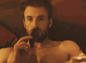 Chris Evans lying in bed and holding a remote