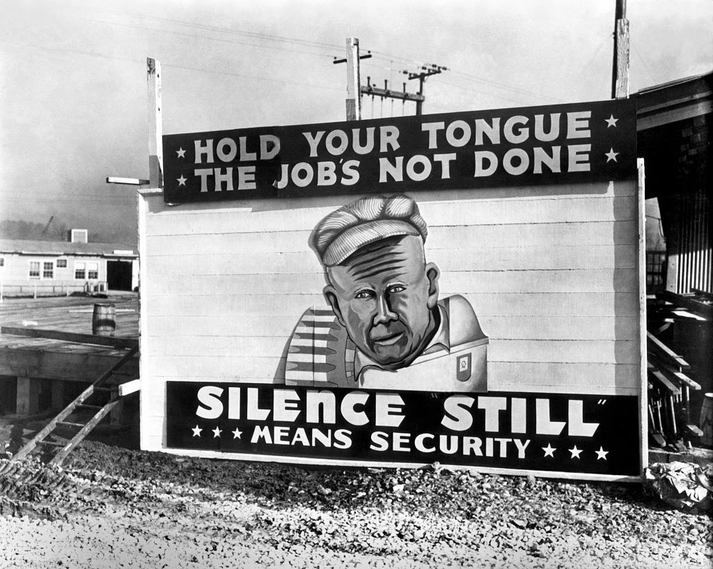Sign that reads, &quot;Hold your tongue. The job&#x27;s not done. Silence still means security.&quot;