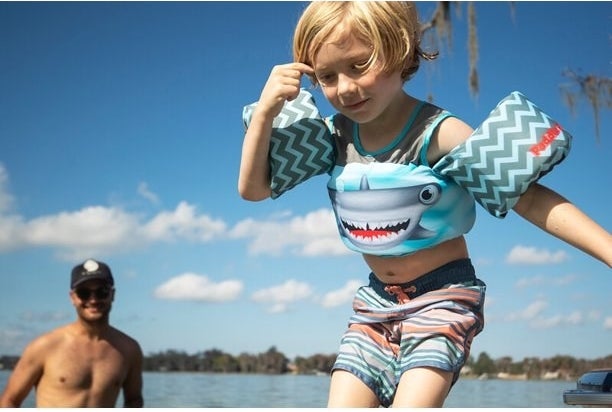 Man watching little boy with paddle pal on