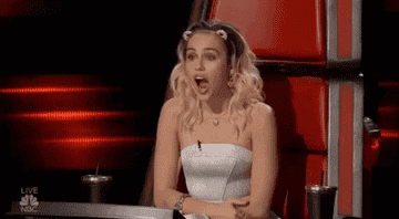 miley cyrus in the voice touching her chest with emotion