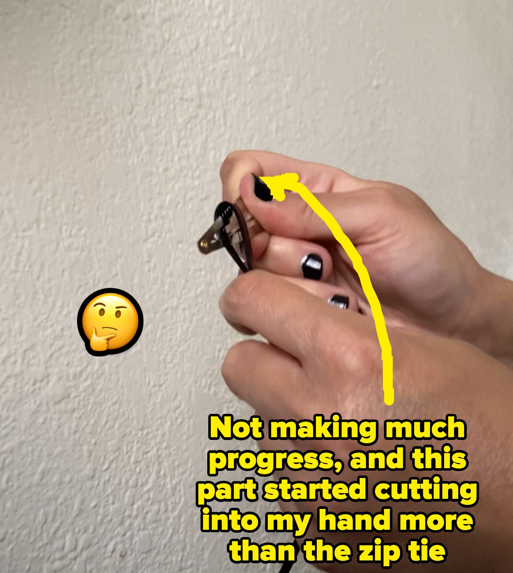 the author bending a zip tie over the edge of the hair clip that has teeth without making much progress in cutting it