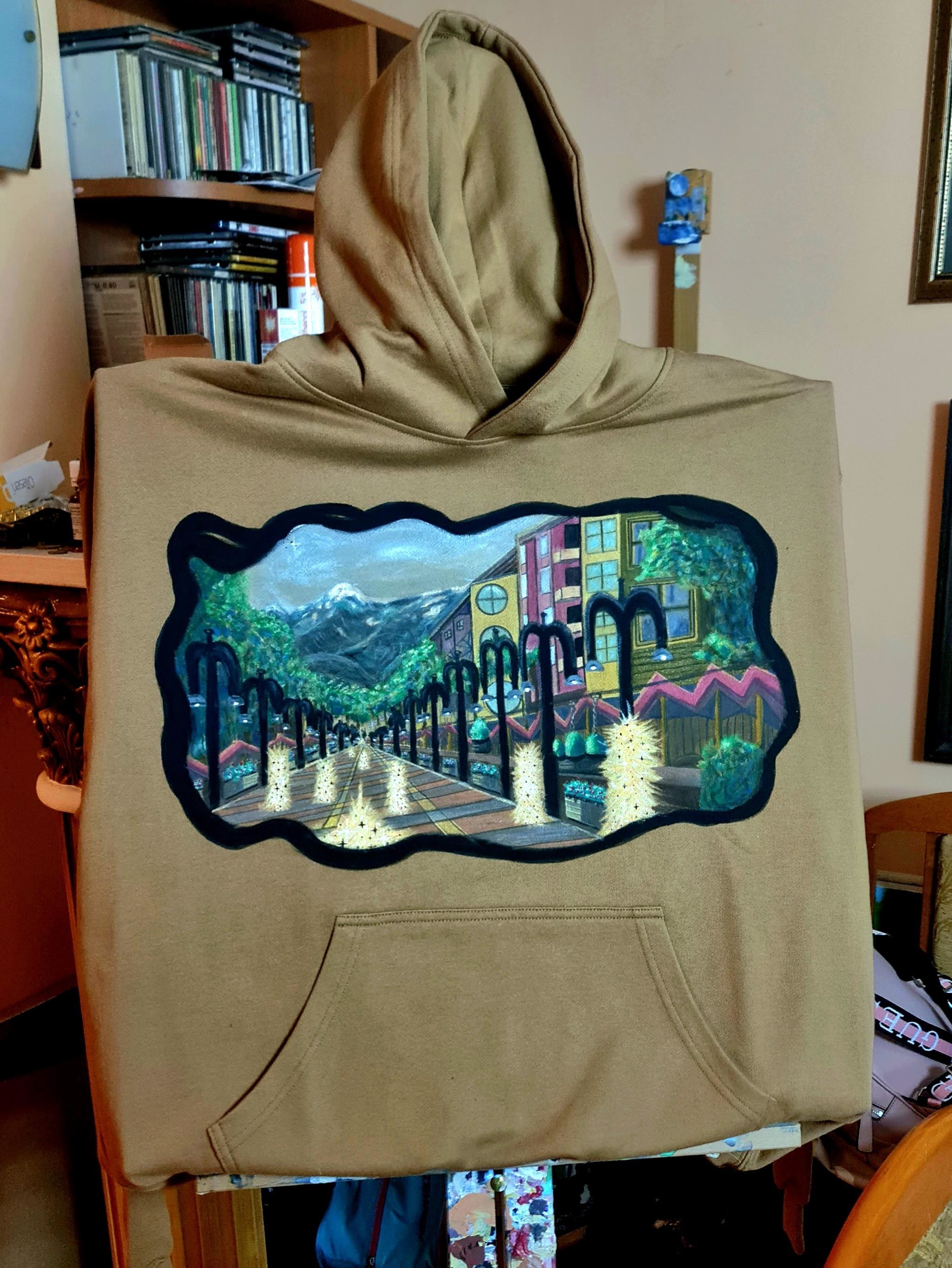 a painting of a street and landscape on a hoodie