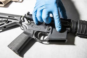 An image of a police service technician inspecting a seized ghost gun